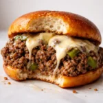 plate of gordon ramsay philly cheesesteak sloppy joes with melted cheese and seasoned beef on a toasted bun