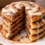 cinnamon roll pancakes with creamy frosting on a plate perfect brunch dish
