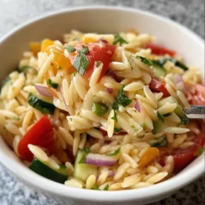 Delicious orzo salad with colorful vegetables in a bowl